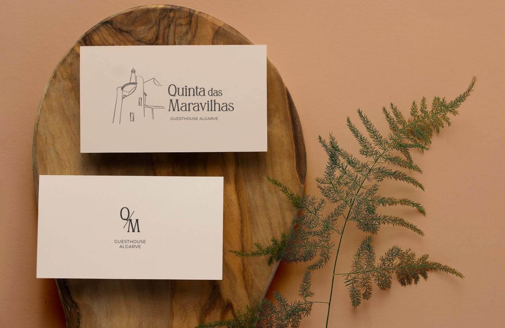 Quinta-das-Maravilhas-Guesthouse-Brand-Identity-Logo-Design-businesscard-on-wood-with-plant_top-view